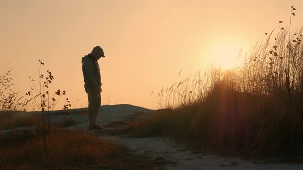 A Man With His Head Bowed Against The Sunset, A Sad Young Man. Problems Or Depression In A Man