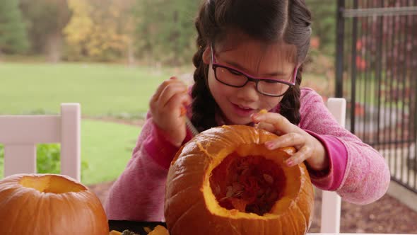 Young girl carving pumpkin for Halloween