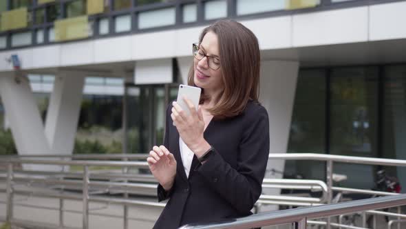 Business Woman Standing in Front of Office Building Using Phone