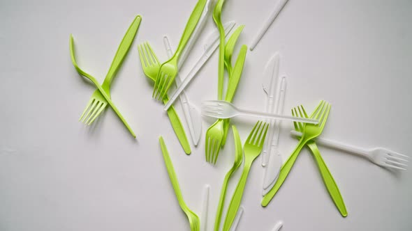 Lots Plastic Forks and Eating Utensils Are Falling on White Background