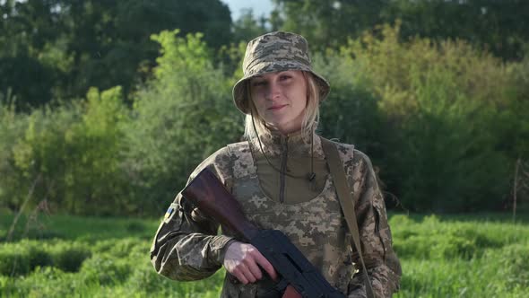 Portrait of Female Soldier in Camouflage Uniform Looking at Camera