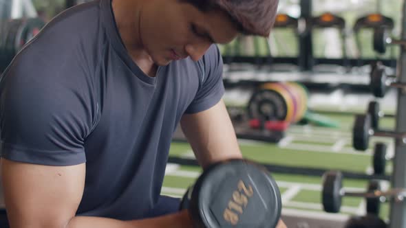 Handsome young athlete Asian guy exercise doing squat fat burning workout in fitness class.