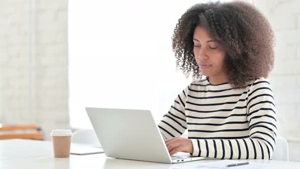 Appreciative African Woman with Laptop Doing Thumbs Up