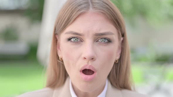 Close Up of Face of Young Businesswoman Looking Shocked at Camera