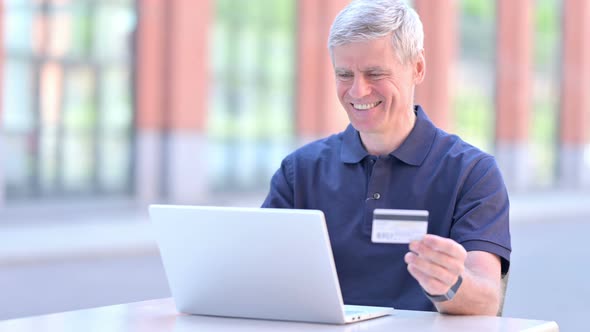 Outdoor Middle Aged Businessman Using Credit Card on Laptop