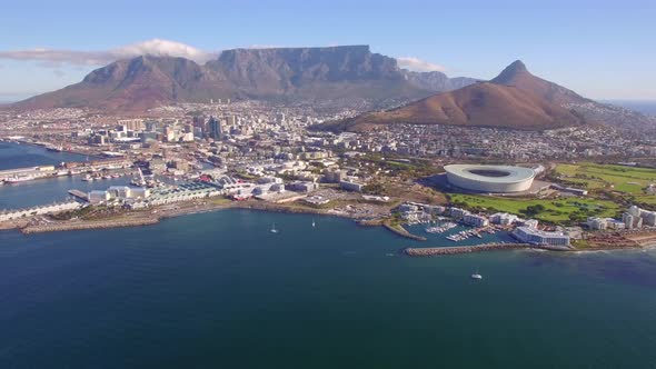 Aerial travel drone view of Cape Town, South Africa with Table Mountain and stadium.