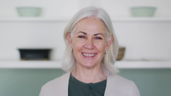 Portrait of happy senior caucasian woman at home smiling to camera