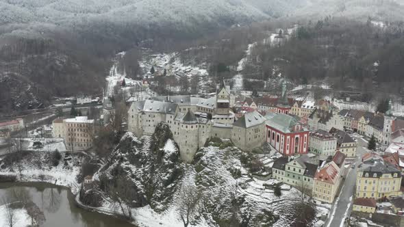 Aerial view of medieval Loket castle, Czech Republic in snowy winter landscape. 12th century landmar