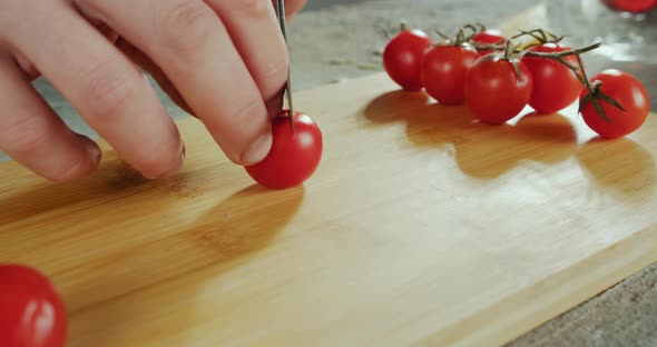 Close Up Fooage of Chef's Hands Cutting a Fresh Tomato with Knife on Wooden Board