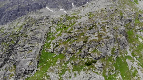 AERIAL: Steep Side of a Mountain covered with Green Grass