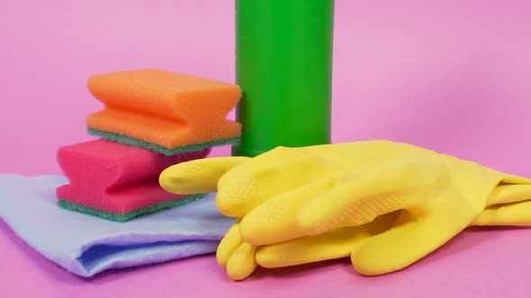 A Plastic Bottle of Cleanser Sponges Orange Latex Gloves and a Cleaning Cloth