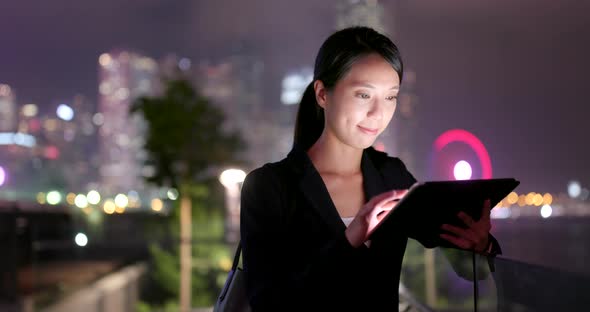 Business woman use of tablet computer at night