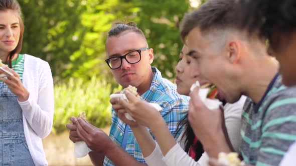 Friends Eating Sandwiches or Burgers in Park 30