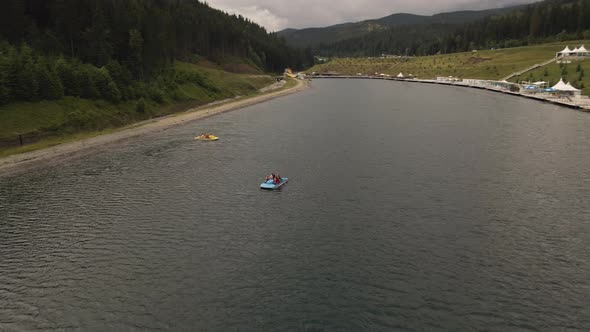 Two catamarans out on lake at Bukovel water park. Aerial.