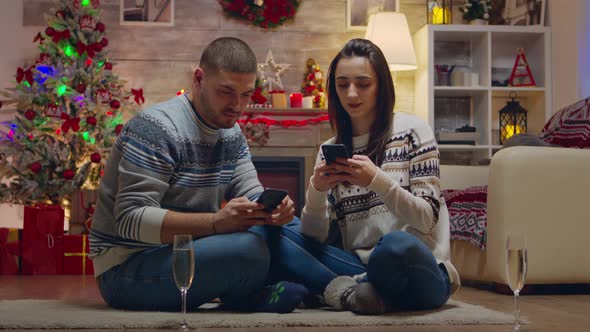 Couple Celebrating Christmas in Front of Fireplace