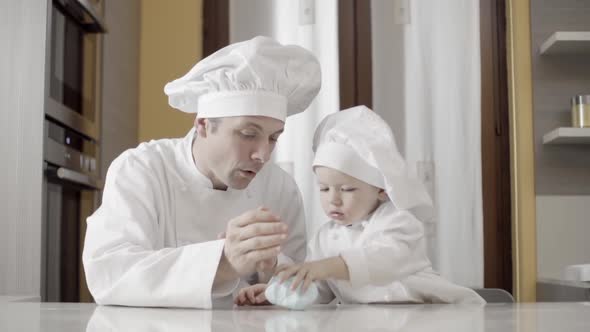 Dad and Son Rolling Out Blue Sugar Paste in Their Home Kitchen