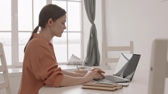 Woman Using Laptop during Breakfast