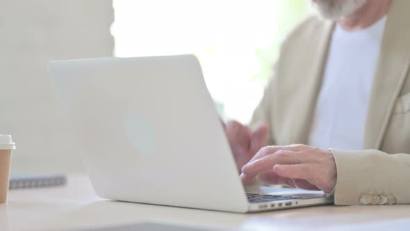 Close Up of Old Man Typing on Laptop