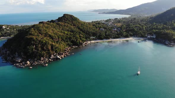 Boat Near Tropical Shore. Amazing Drone View of Modern Yacht Sailing on Calm Sea Water Near Coast of