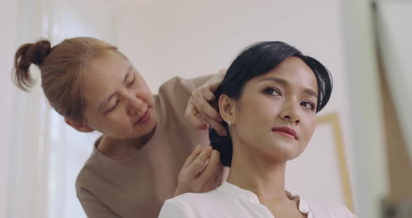 Professional Hairdresser Working With Asian Bride On Wedding Day.