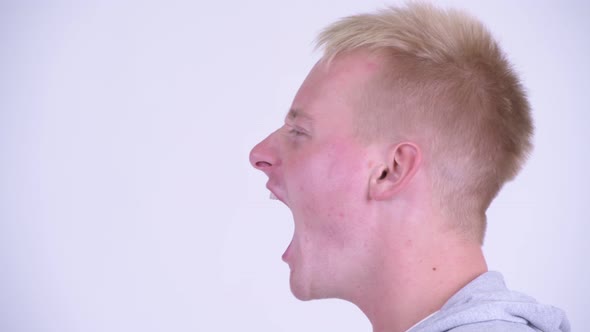 Profile View of Angry Young Blonde Man Shouting and Screaming