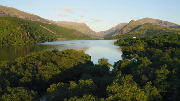 Beautiful landscape of Llyn Padarn Lake surrounded by lush forest and mountains in Snowdonia Nationa