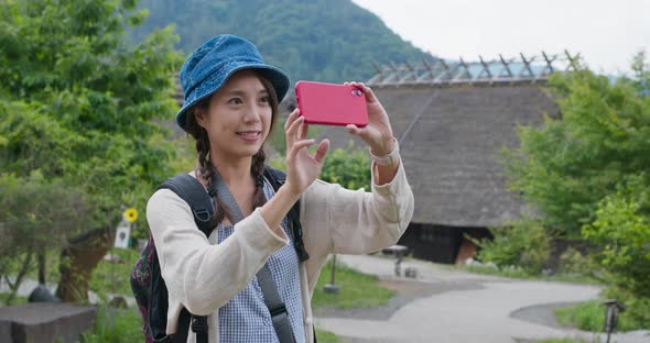 Woman use of cellphone to take photo in Japanese wooden house 