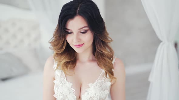 Portrait of a beautiful young bride with wavy hairdo smiling into camera. Glamour model