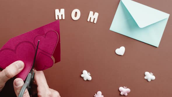 Hand Cuts Red Hearts for Mother's Day Background