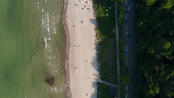 Aerial Birds Eye Overhead Top Down View of Baltic Sea Coastline Beach with People Walking on Shore