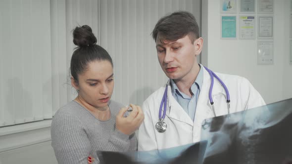 Doctor Explaining Xray Scanning Results to His Female Patient