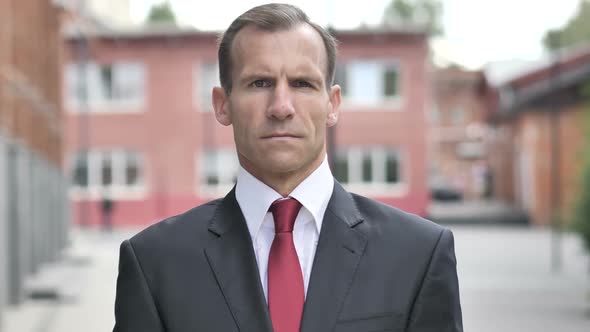 Serious Businessman Standing Outside Office