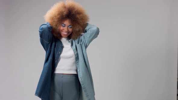 Happy Smiling Mixed Race Black Woman with Big Afro Hair Poses in Studio