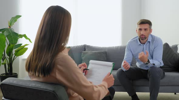 Emotional Adult Man Patient with Mental Health Problems Talking to Therapist