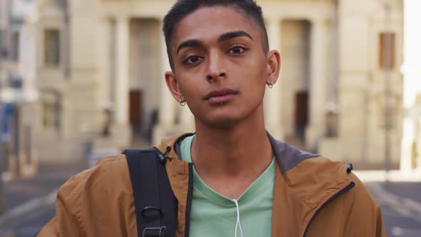 Mixed race man looking at camera and smiling in the street