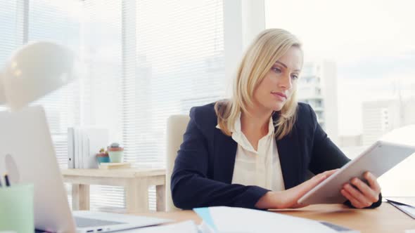 Businesswoman using digital tablet at her desk