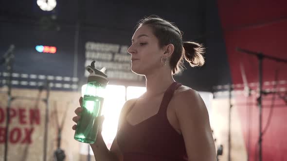 Strong Spanish Woman Drinking and Panting After Training Session