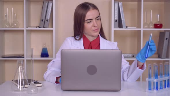 Female Works with Liquid in Lab