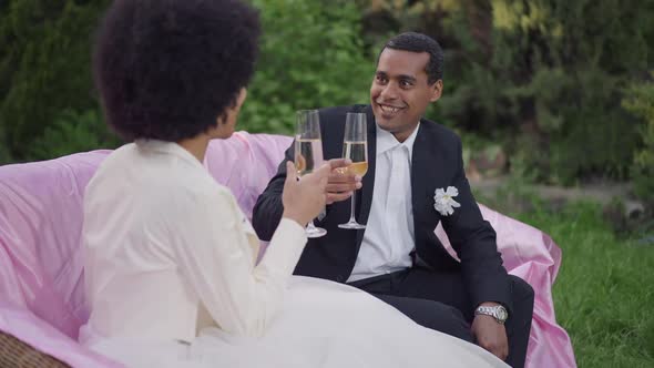 Portrait of Affectionate African American Groom Toasting Clinking Champagne Glass with Loving Bride