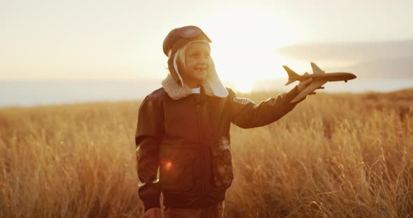 Adorable kid wearing his flight suit and flying his wooden airplane
