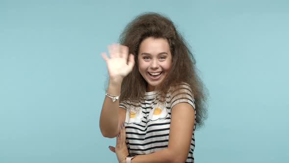 Slow Motion of Glamour Girl with Wavy Hair Saying Hello Coquettish and Smiling Waving Hand at Camera