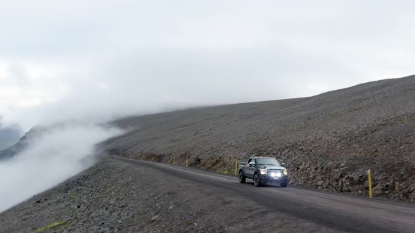 Vehicle Driving At The Road On The Mountainside Under White Cloudy Sky In West Fjords In Iceland. ae