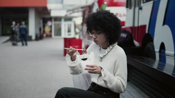 Multiracial young woman has lunch outdoors