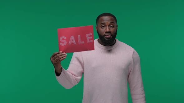 Amazed Young African American Man Guy in Casual Hold Sign with SALE Title and a Wad of Dollars on