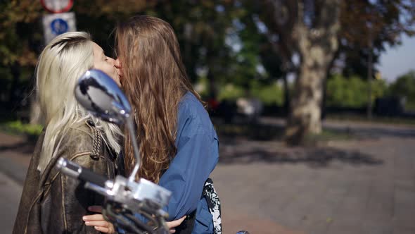 Two Young Women Kissing Mounted on the Motorcycle in the City