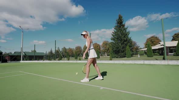 Professional Female Tennis Player Hits the Ball with a Racket Practice Game on the Tennis Court