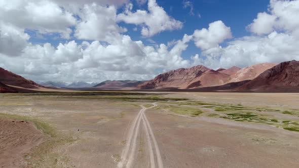 Aerial Over Off Road 4X4 Gravel Trail Path on Arid Colorful Desert Mountains