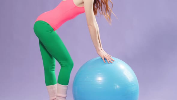 Girl with Long Red Hair Standing Near Blue Fitness Ball