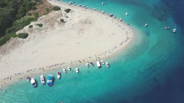 Aerial drone view of iconic small uninhabited island of Marathonisi featuring clear water, sandy sho