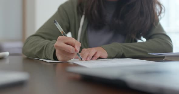 Woman write on the note do revision at home